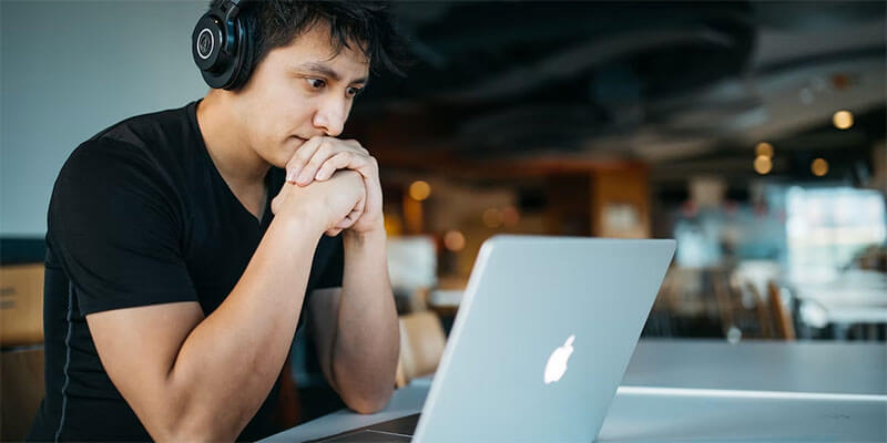 file encryption_man-computer A man wearing headphones stares attentively at his computer