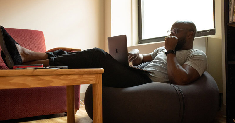 MASV-How-to-Upload-Faster-Browser-man-lounging Man lounging on a bean bag with his legs on a coffee table