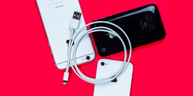 iPhone 13 ProRes Files_lightning cable An Apple lightning cable sits on top of three iPhones